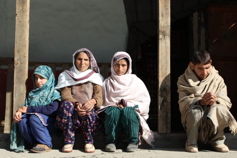 Hajra Bibi with her children sitting in the veranda of her home.